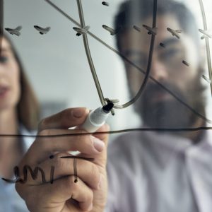 cerca-del-hombre-explicando-analisis-de-negocios-su-colega-con-un-grafico-en-la-pizarra