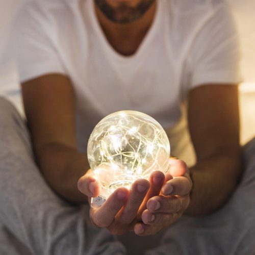 primer-plano-de-hombre-tenencia-brillante-transparente-esfera
